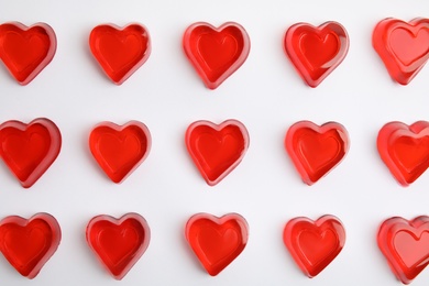 Photo of Sweet heart shaped jelly candies on white background, flat lay