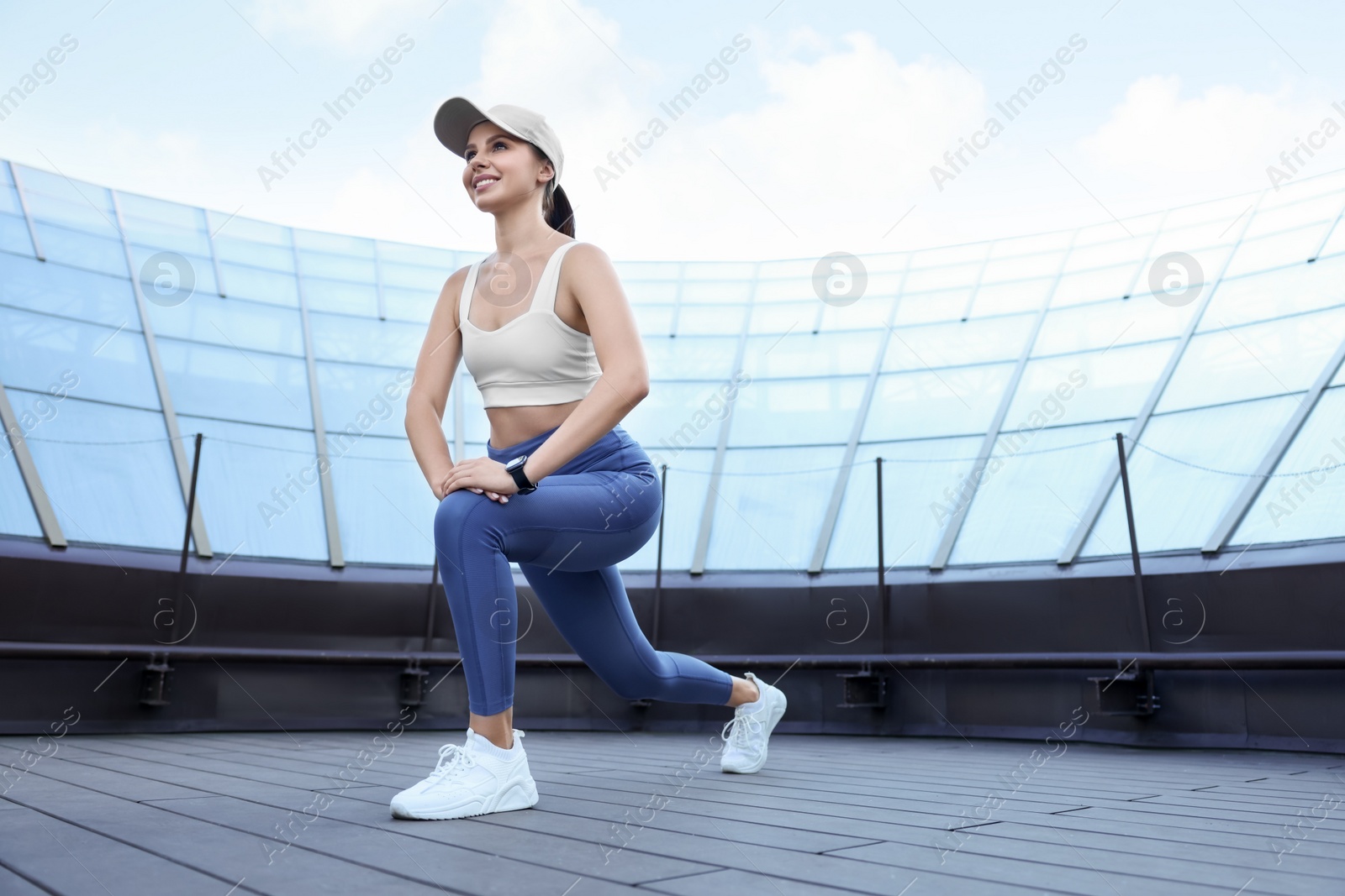 Photo of Beautiful woman in stylish sportswear doing exercises outdoors. Space for text