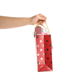 Photo of Woman holding shopping paper bag with presents on white background, closeup