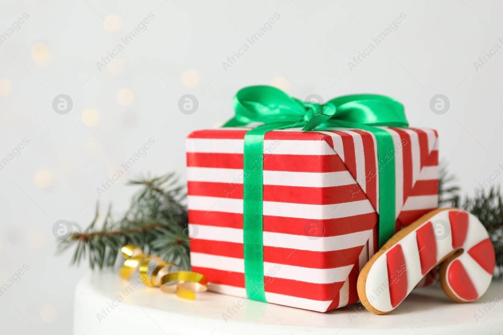 Photo of Christmas gift box and gingerbread on white table, closeup