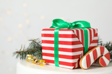 Photo of Christmas gift box and gingerbread on white table, closeup