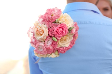 Photo of Wedding couple with beautiful bouquet on beach