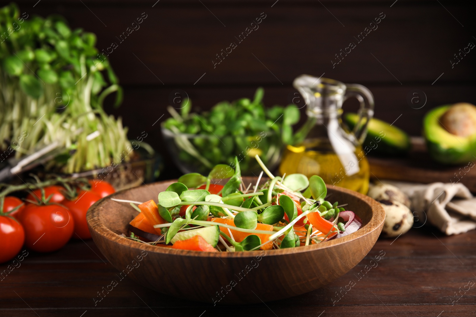 Photo of Salad with fresh organic microgreen in bowl on wooden table, closeup