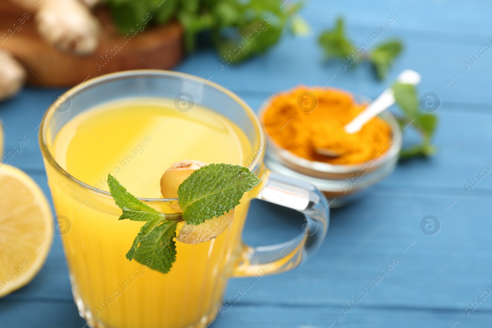 Photo of Immunity boosting drink and ingredients on blue table, closeup