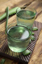 Photo of Fresh aloe drink in glasses on wooden table