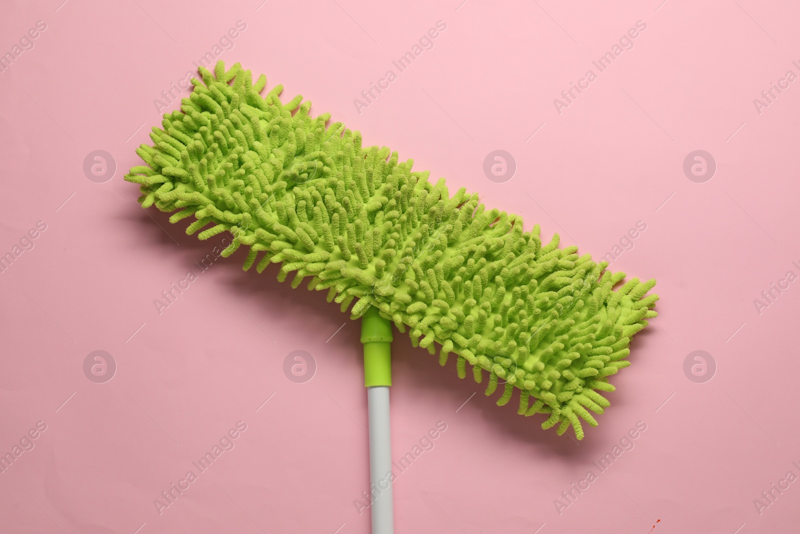 Photo of Mop with plastic handle on pink background, top view