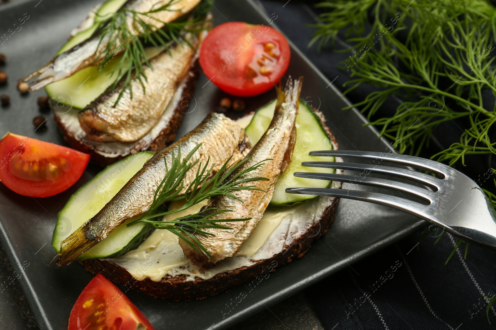 Delicious sandwiches with sprats, cucumber and dill served on plate, closeup Photo of Delicious sandwiches with sprats, cucumber and dill served on plate, closeup