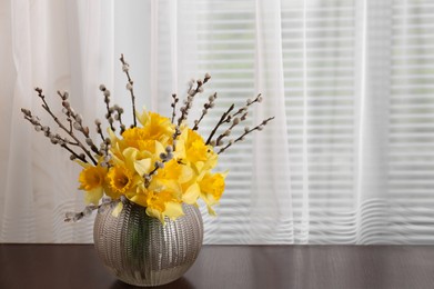 Bouquet of beautiful yellow daffodils in vase on table. Space for text