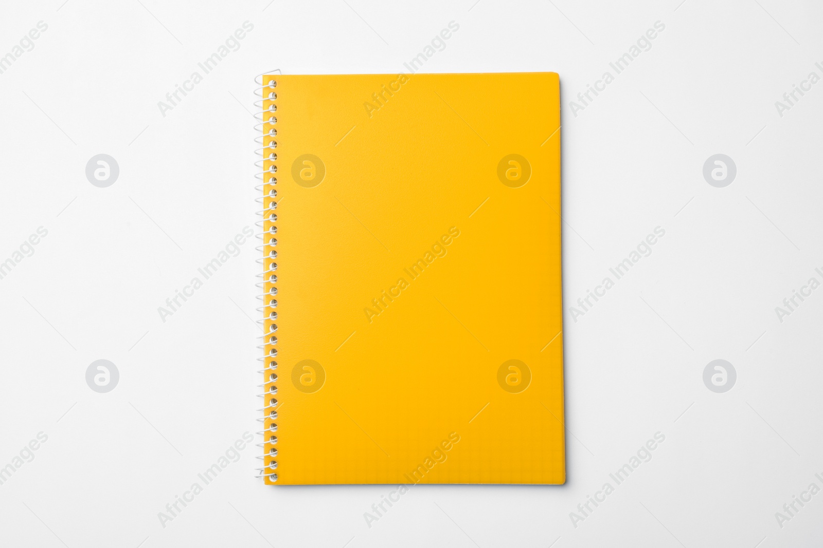 Photo of Stylish yellow notebook isolated on white, top view