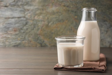 Photo of Glassware with lactose free milk on wooden table, space for text