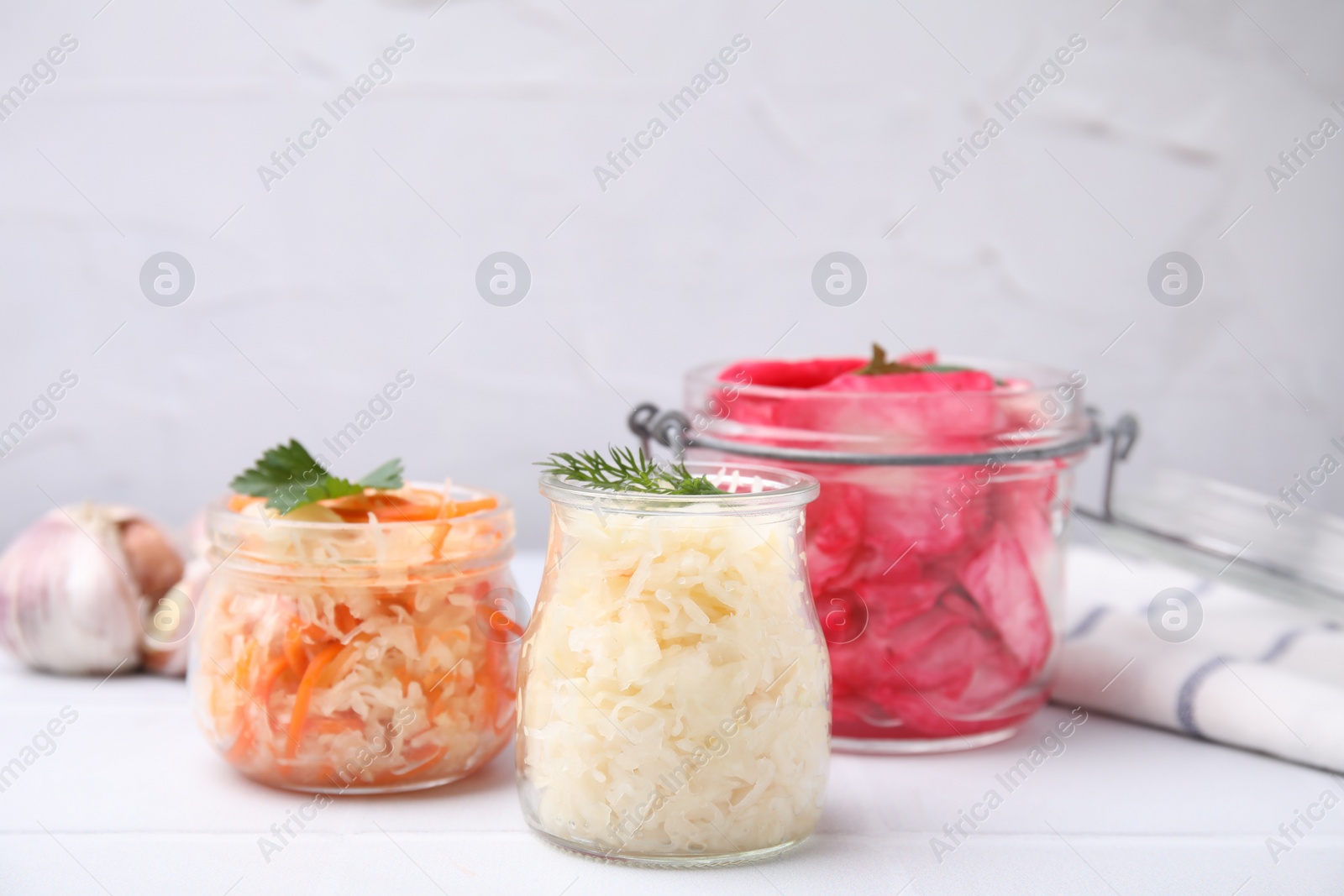 Photo of Delicious sauerkraut prepared according to different recipes on white table