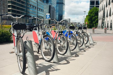 Photo of Many electrical bikes on street near buildings outdoors