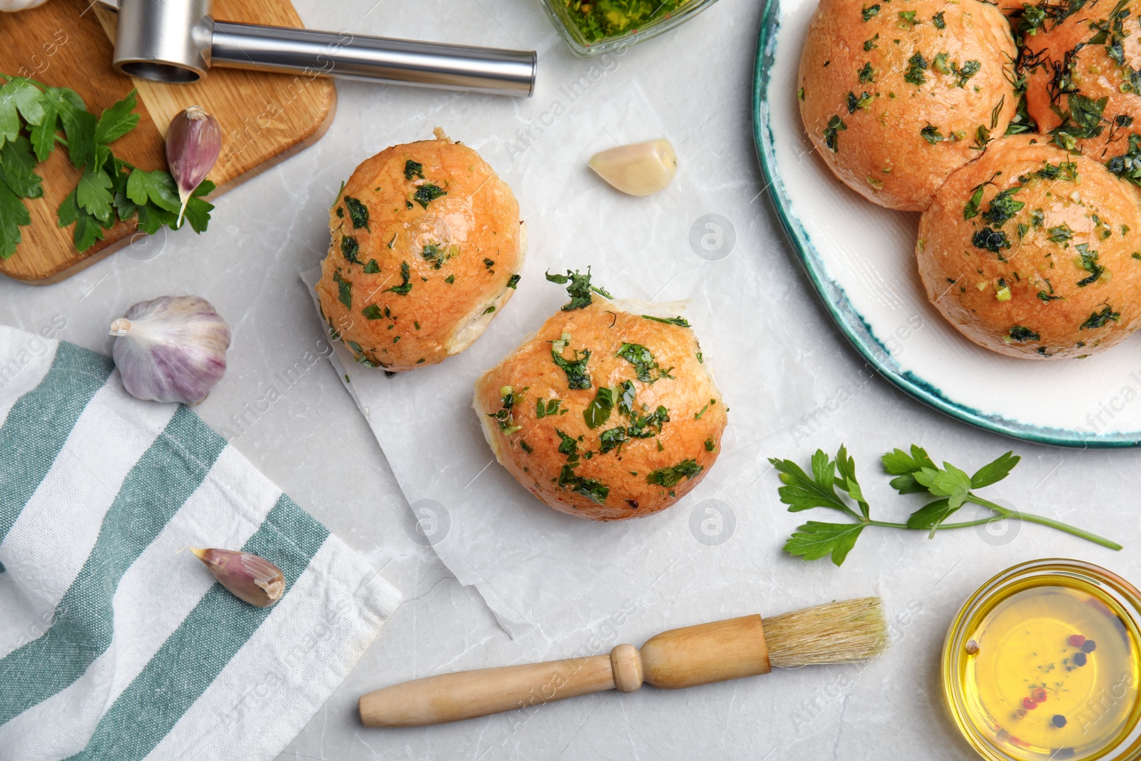 Photo of Traditional Ukrainian bread (Pampushky) with garlic on light grey marble table, flat lay