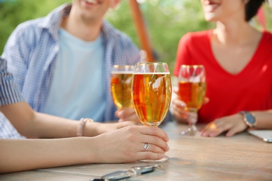 Photo of Young people with glasses of cold beer at table