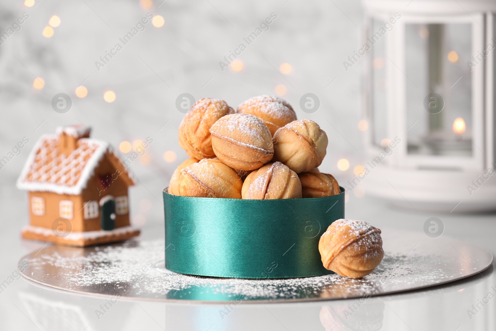 Photo of Box with delicious nut shaped cookies on white table, closeup