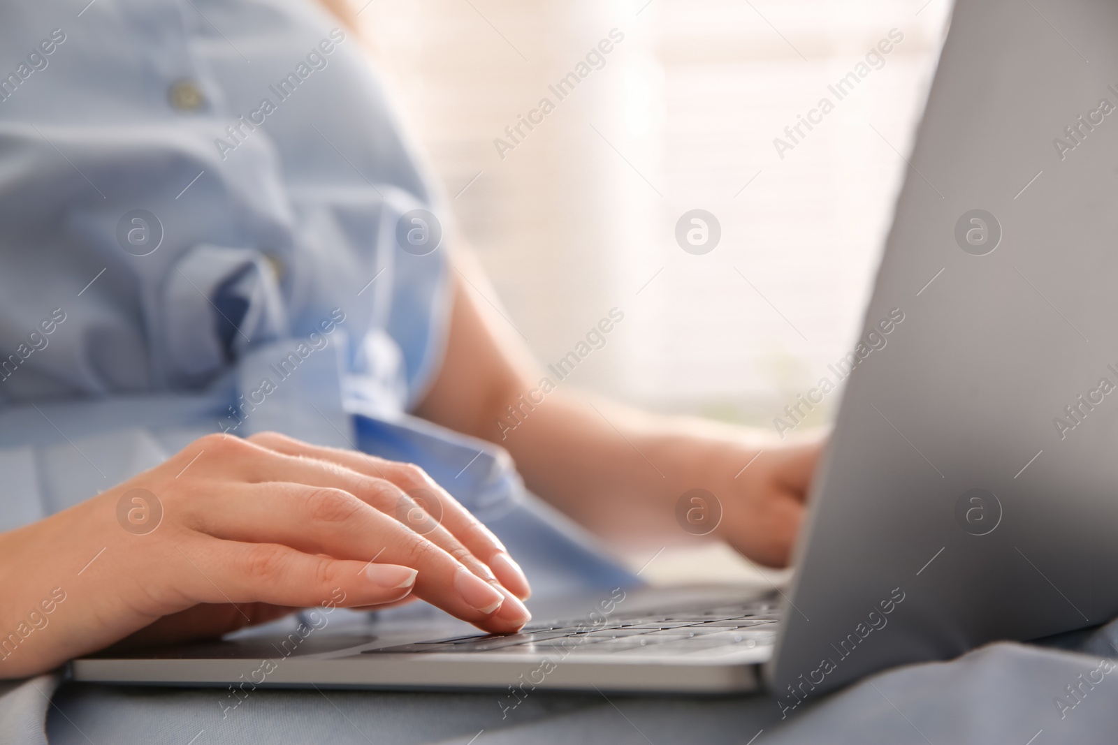 Photo of Woman working with modern laptop indoors, closeup