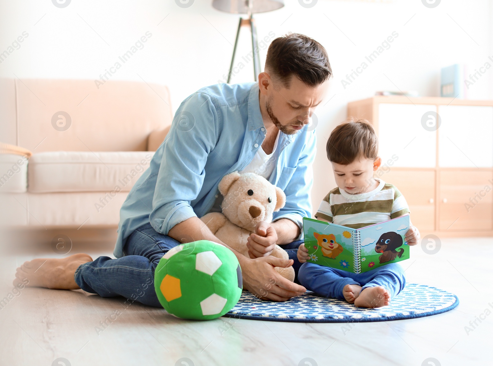 Photo of Dad and his son reading book at home