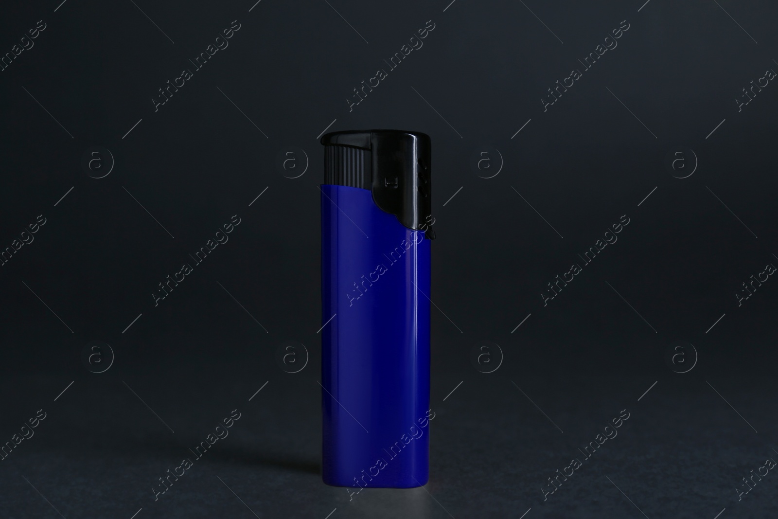 Photo of Stylish small pocket lighter on wooden table against black background