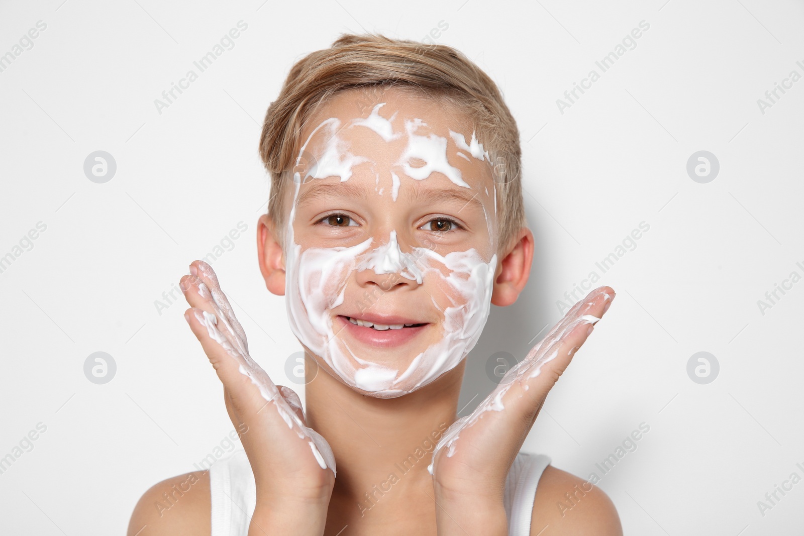 Photo of Cute little boy with soap foam on face against white background