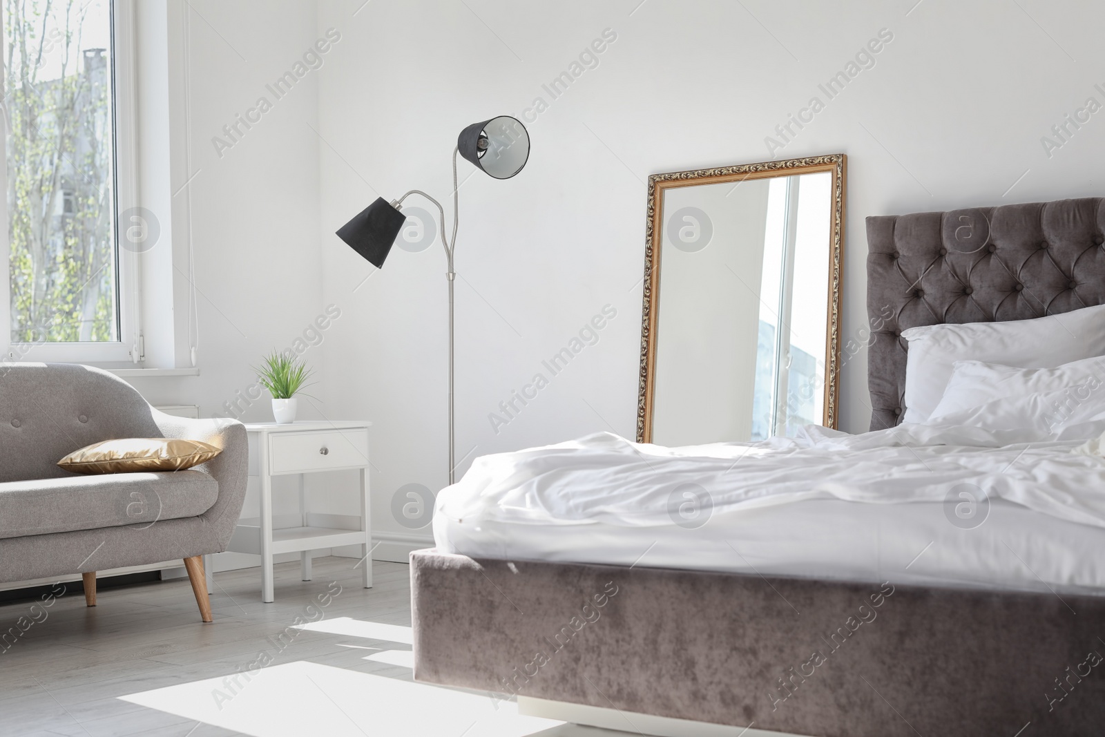 Photo of Elegant room interior with large mirror and comfortable bed