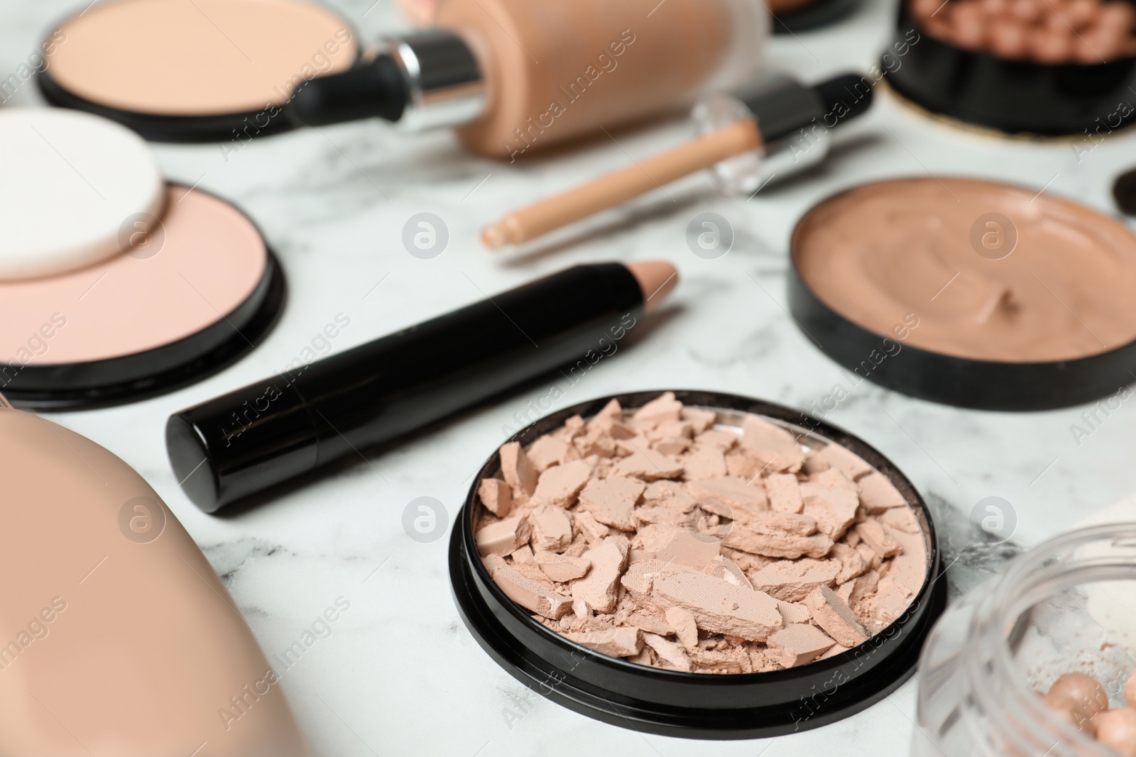 Photo of Composition with skin foundation, powder and beauty accessories on marble background