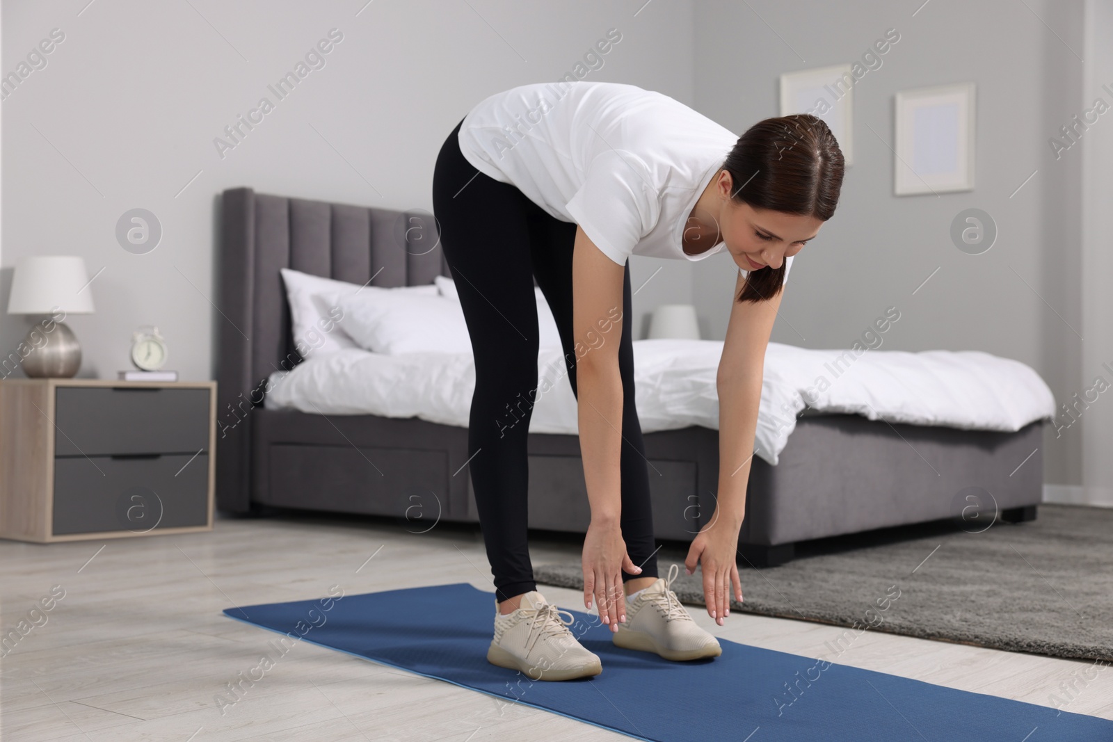 Photo of Morning routine. Woman doing stretching exercise at home