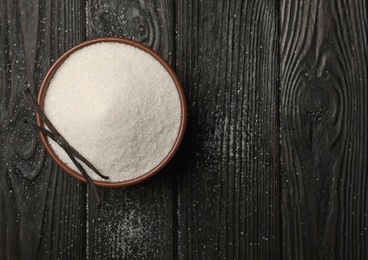 Photo of Bowl with vanilla sugar on wooden background, top view