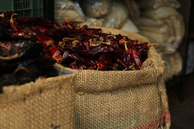 Pile of dried guajillo peppers in burlap, closeup
