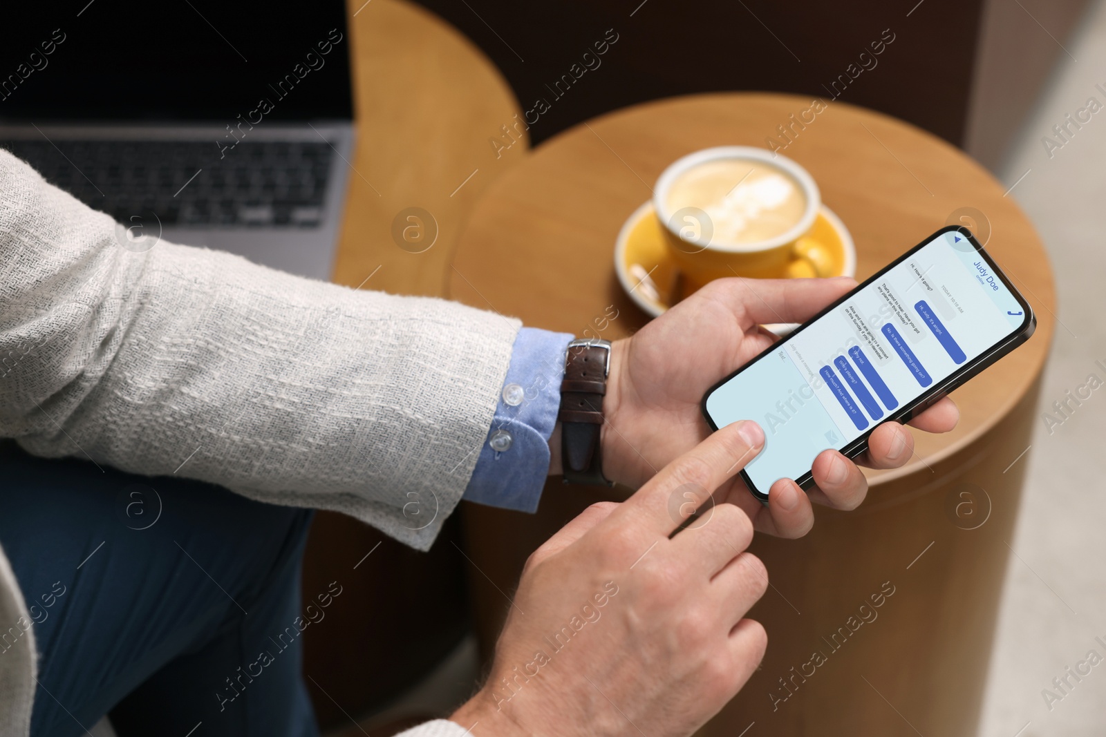 Image of Man texting via mobile phone indoors, closeup. Device screen with messages