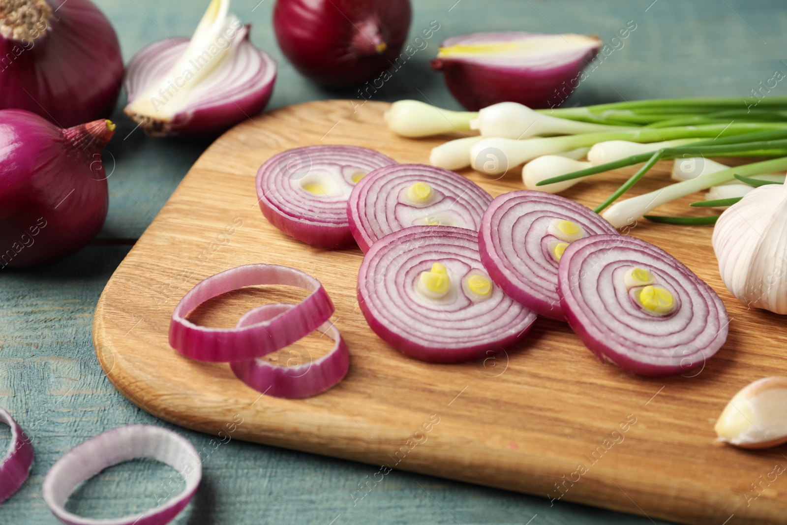 Photo of Composition with cut red onion on light blue wooden table