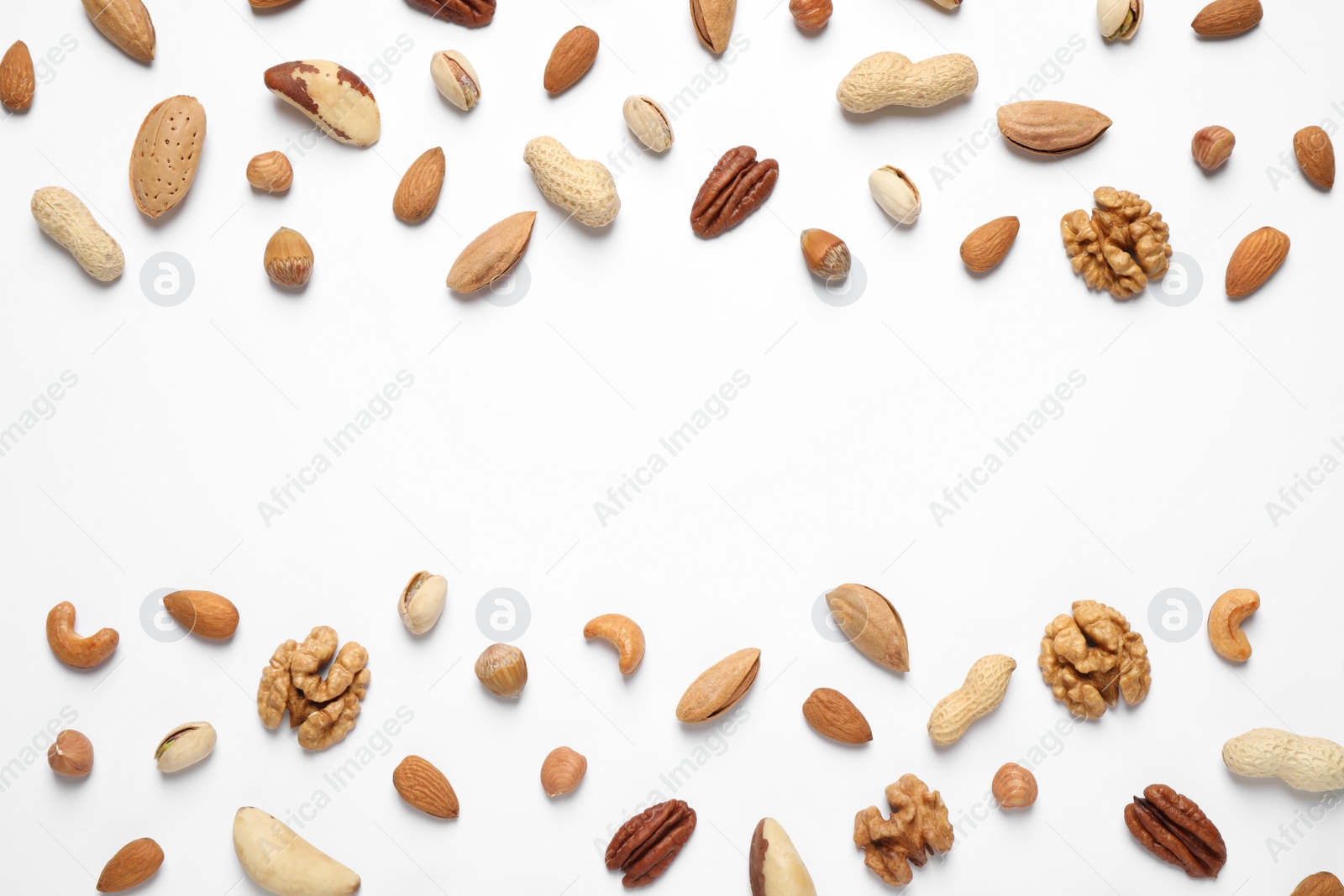 Photo of Different delicious nuts on white background, flat lay. Space for text