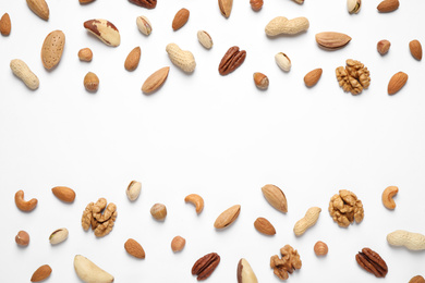 Photo of Different delicious nuts on white background, flat lay. Space for text