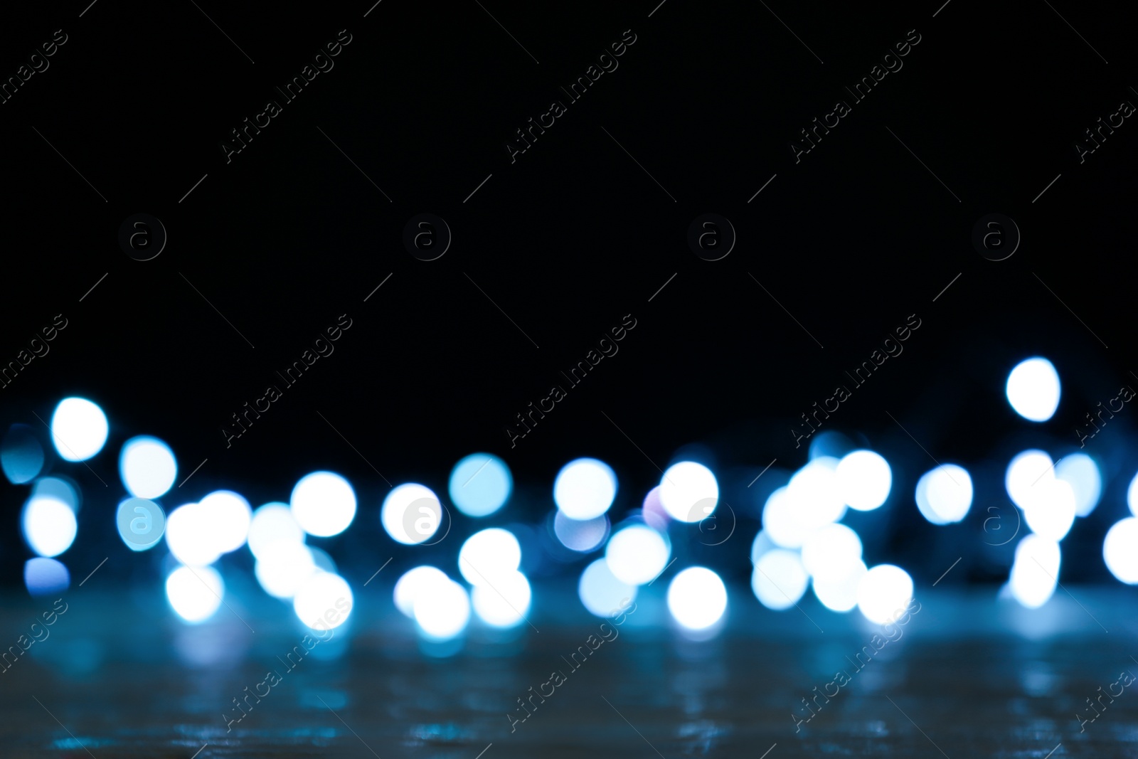 Photo of Blurred view of beautiful lights on black background. Bokeh effect