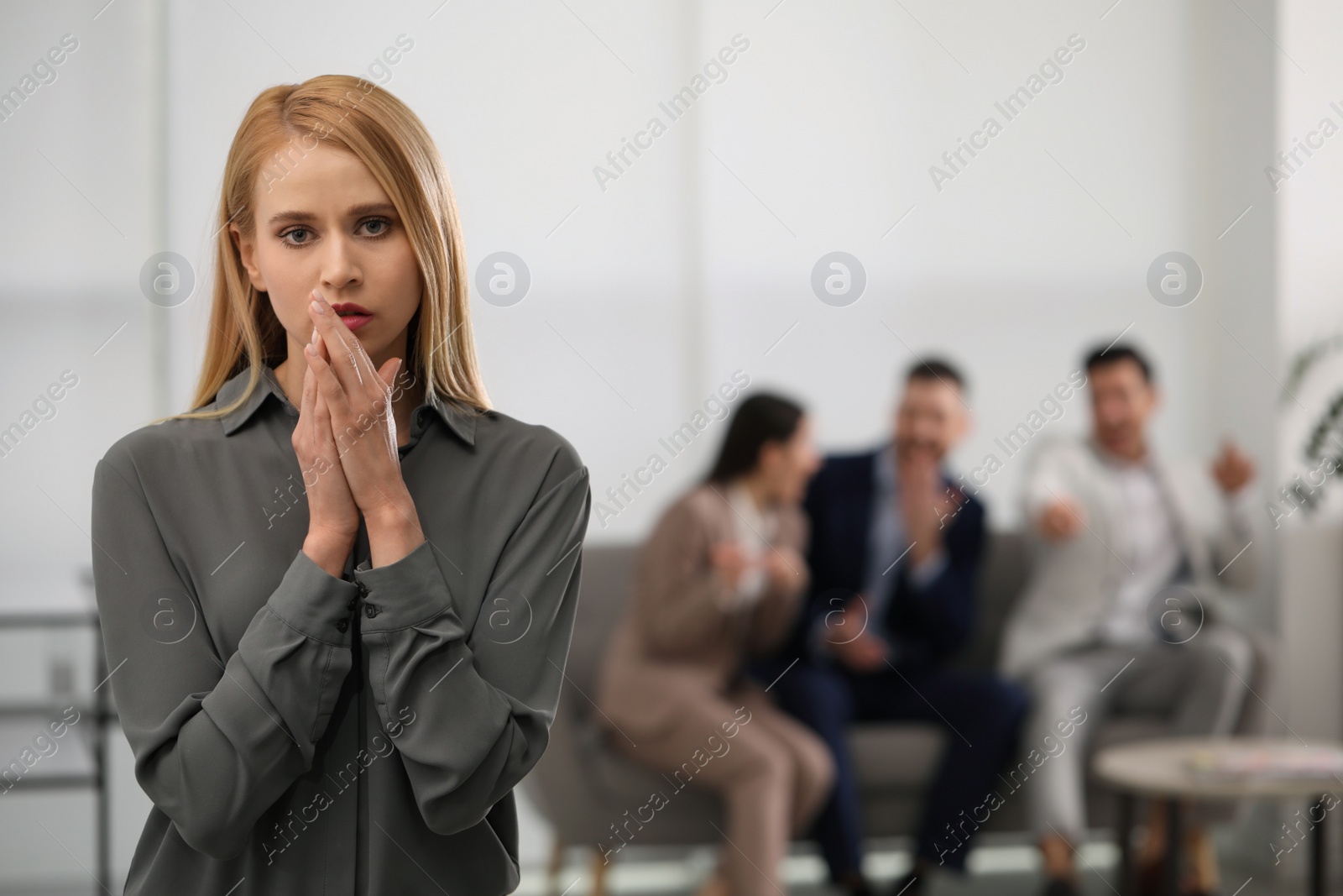 Photo of Coworkers bullying their colleague in office, space for text