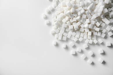 Photo of Refined sugar cubes on light background, top view