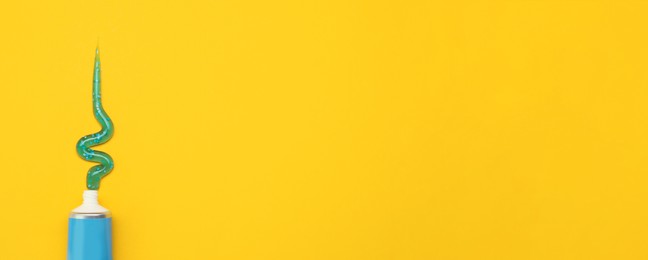 Image of Tube with squeezed out toothpaste on yellow background, top view with space for text. Banner design