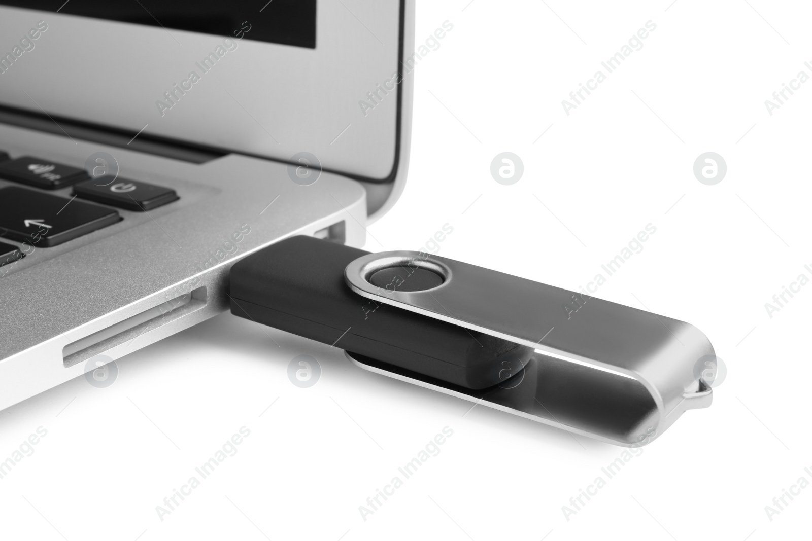 Photo of Modern usb flash drive attached into laptop on white background, closeup