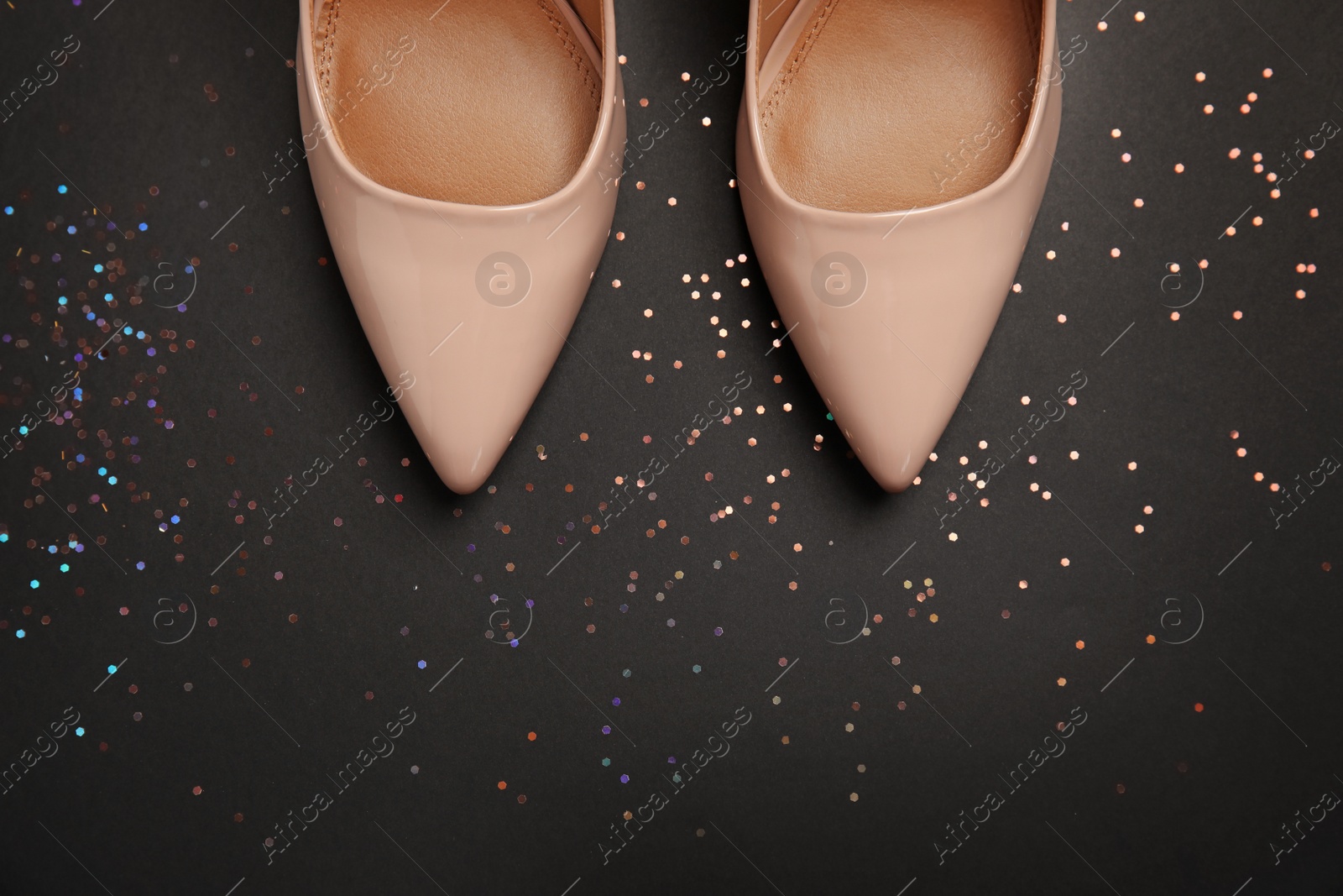 Photo of Pair of beautiful shoes and space for text on dark background, top view