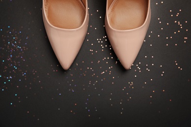 Photo of Pair of beautiful shoes and space for text on dark background, top view