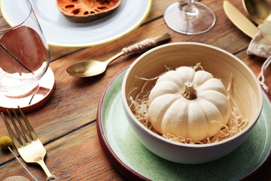 Photo of Autumn table setting with pumpkin and decor on wooden background