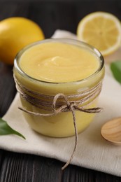 Photo of Delicious lemon curd in bowl on wooden table, closeup