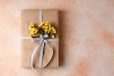 Book decorated with flowers on beige textured background, top view. Space for text