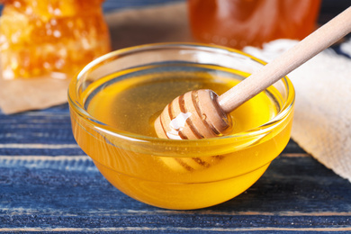 Photo of Tasty fresh honey on blue wooden table