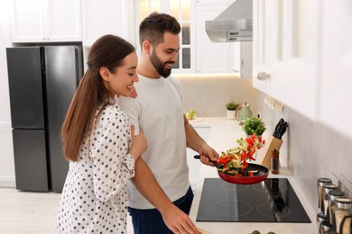 Happy lovely couple cooking together in kitchen