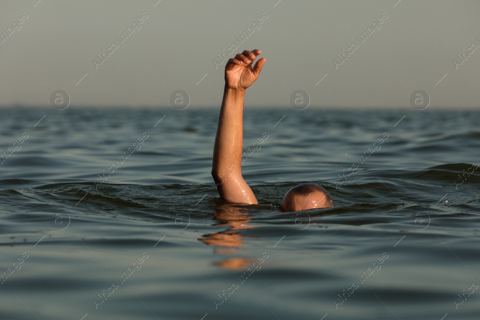 Photo of Drowning man reaching for help in sea