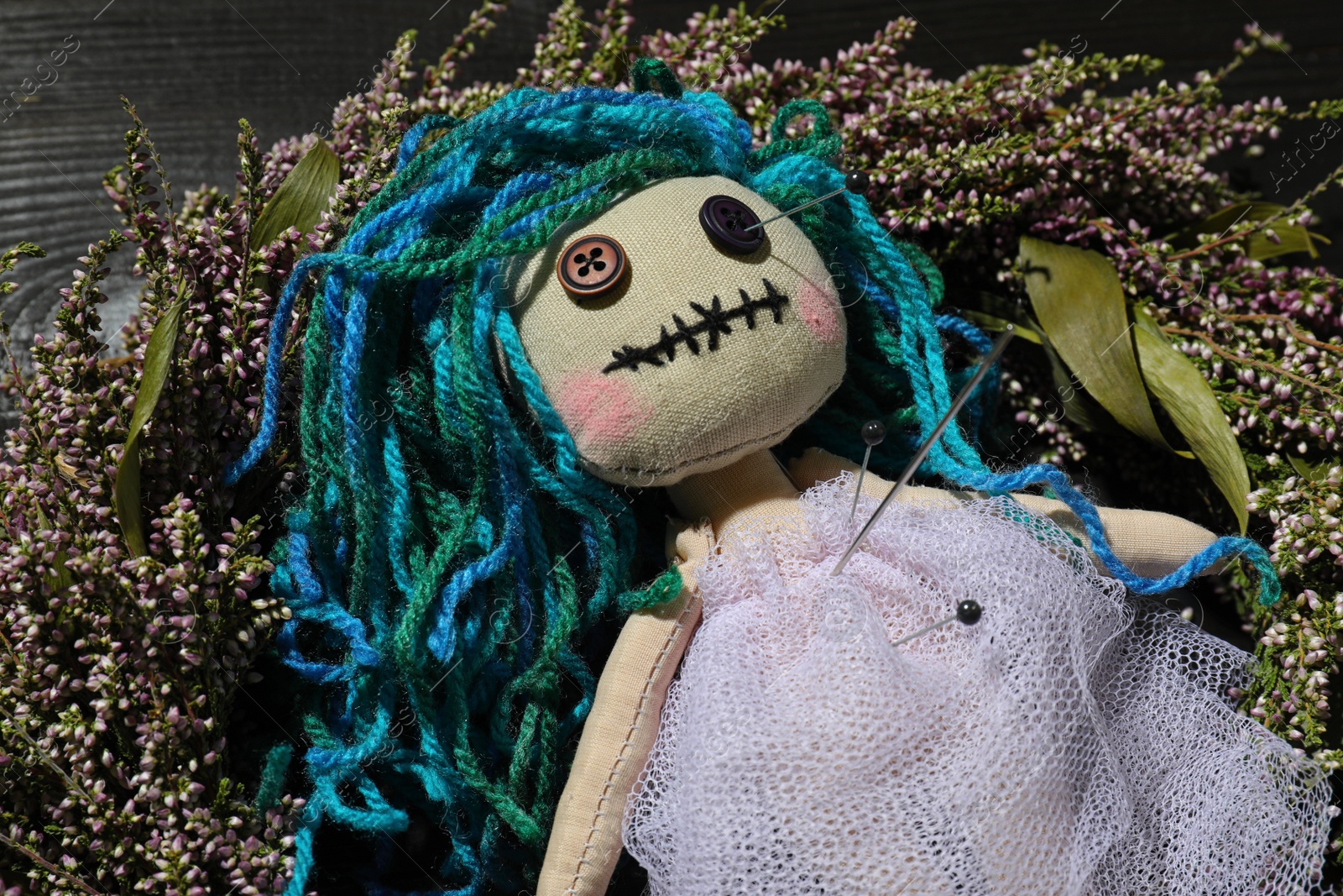 Photo of Female voodoo doll with pins on wreath, closeup