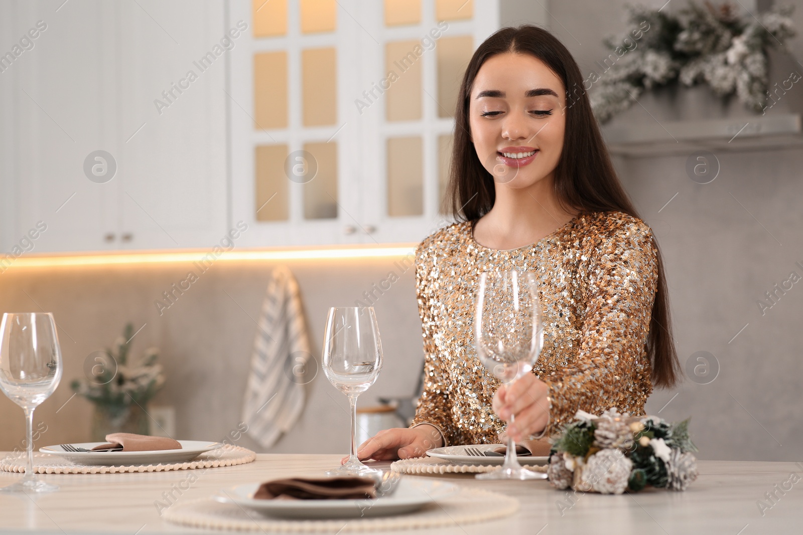 Photo of Happy woman serving table for Christmas in kitchen. Space for text