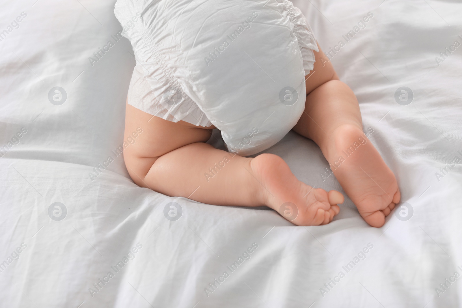 Photo of Cute little baby lying on bed, closeup of legs