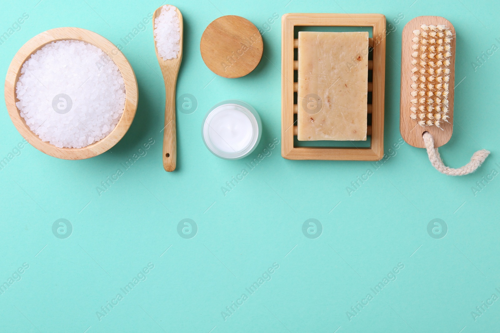 Photo of Jar of cream and body care products on turquoise background, flat lay. Space for text