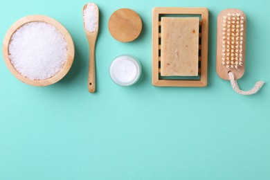 Photo of Jar of cream and body care products on turquoise background, flat lay. Space for text